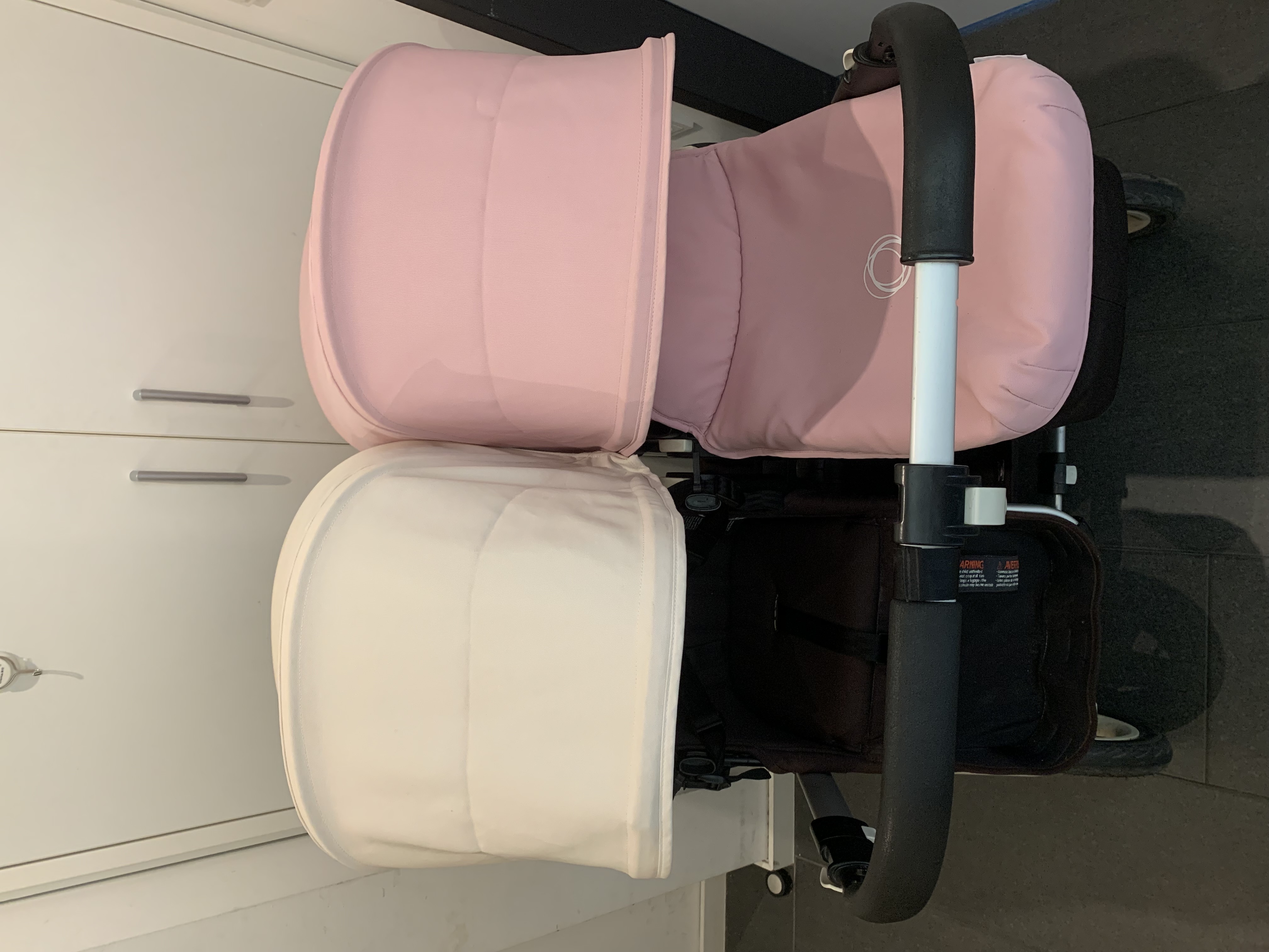 Configuration type Bugaboo Donkey Duo avec nacelle rose et second siège côte à côte.