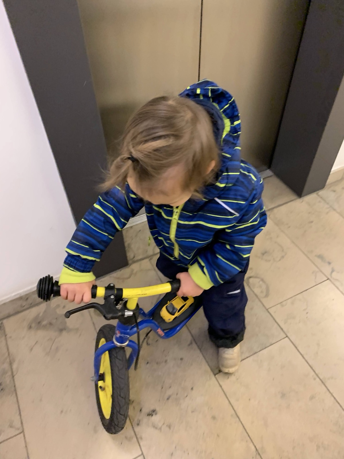 Mein Sohn lernt im Hausflur, das Laufrad zu halten.