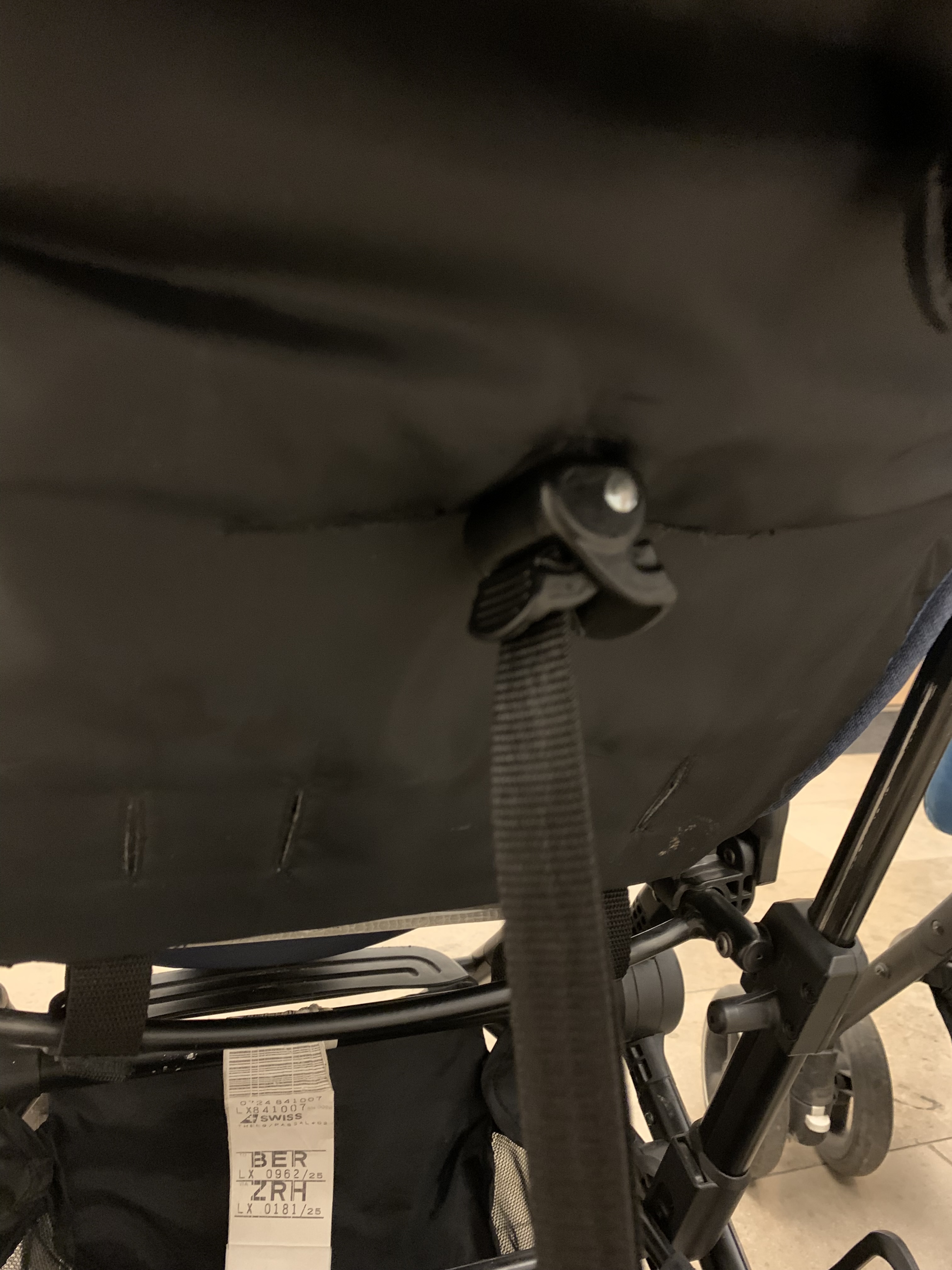 A close-up of one seat recline adjuster, the small strap-and-buckle detail that controls how upright or reclined the backrest sits.