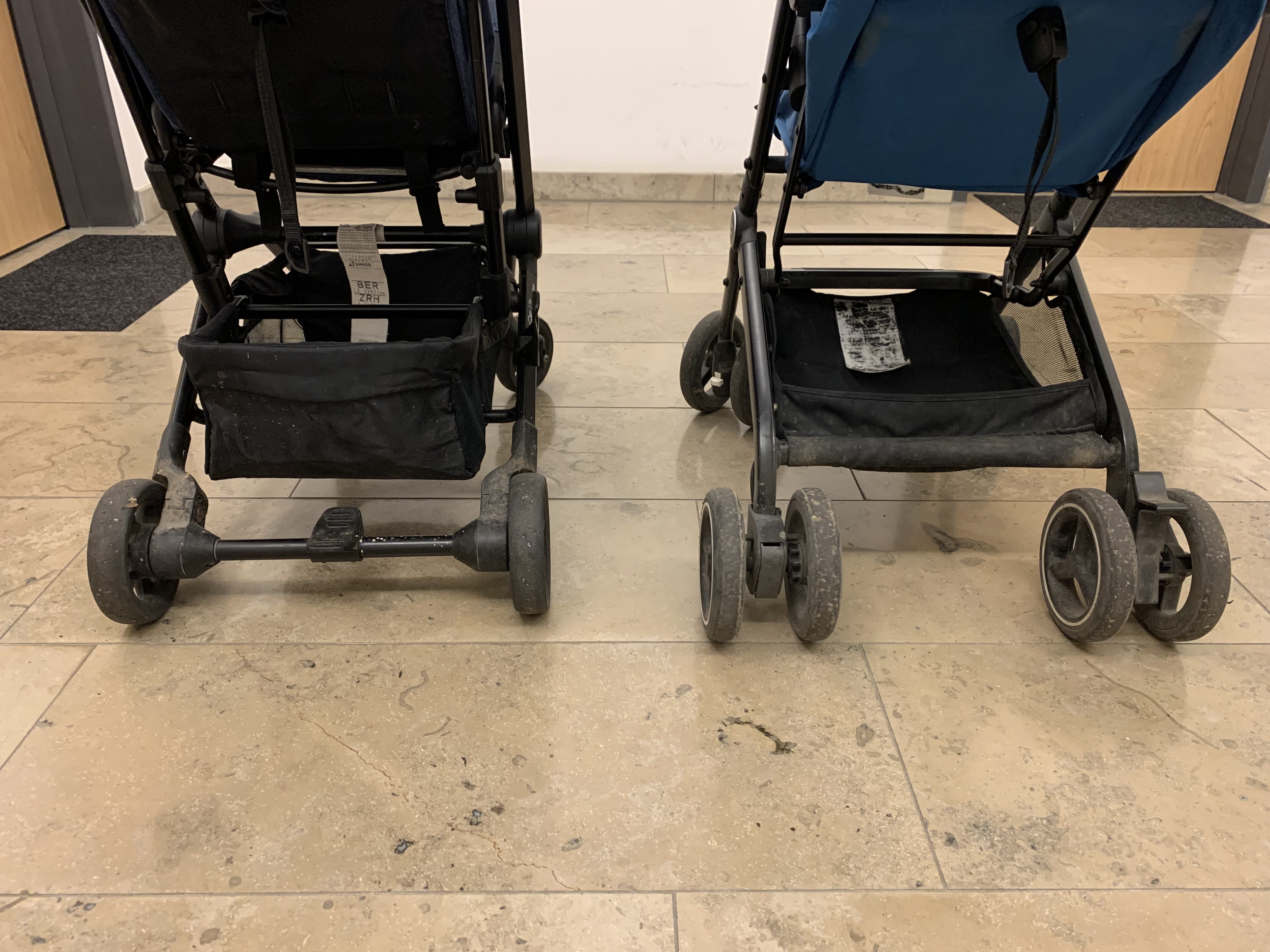 The lower rear frames and wheels of the two strollers, useful for seeing why the GB Qbit+ feels more substantial while the Easywalker feels lighter.