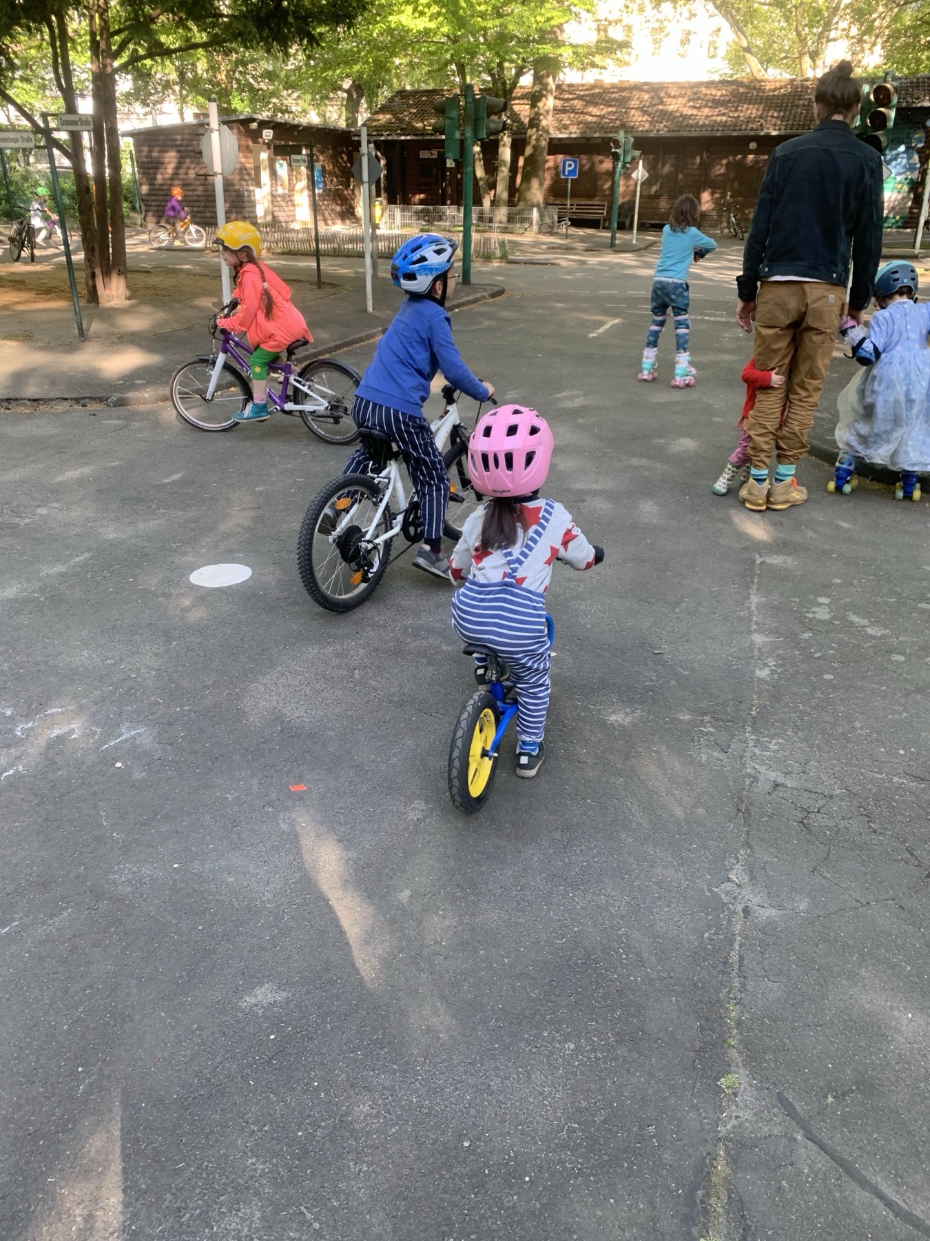 My son and daughter wearing blue and pink helmets in a traffic practice area.