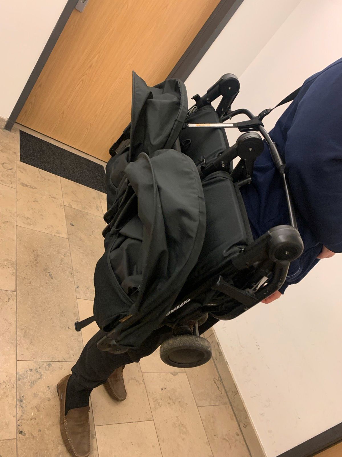 Je porte la Mountain Buggy Nano Duo pliée.
