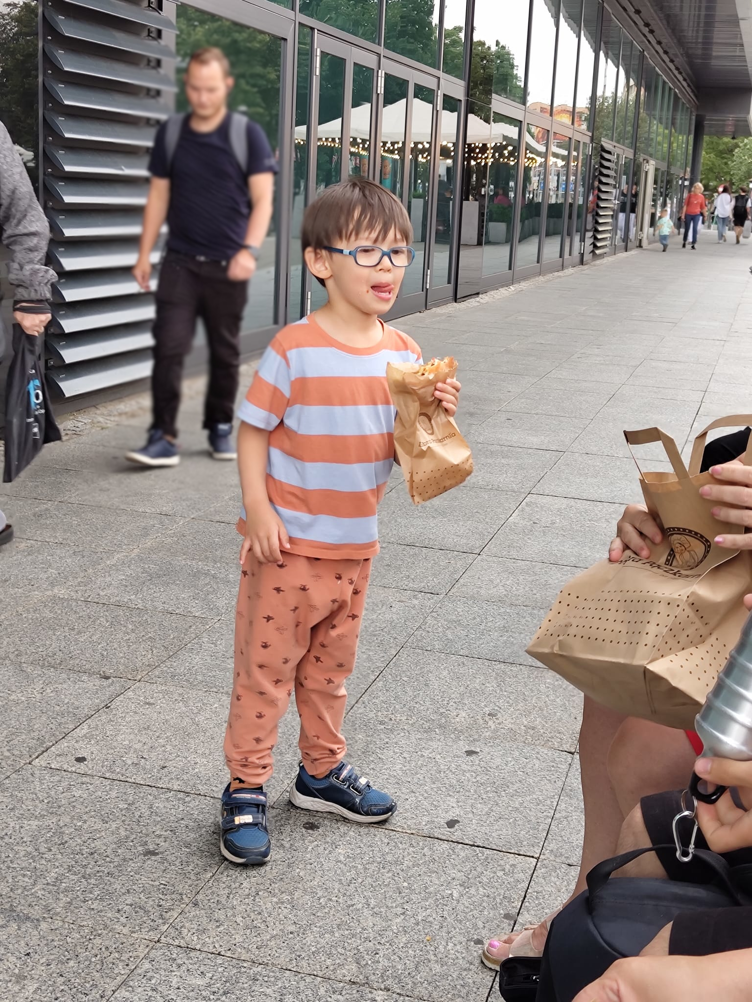 Vår son äter Pączki utanför Galaxy Centrum.