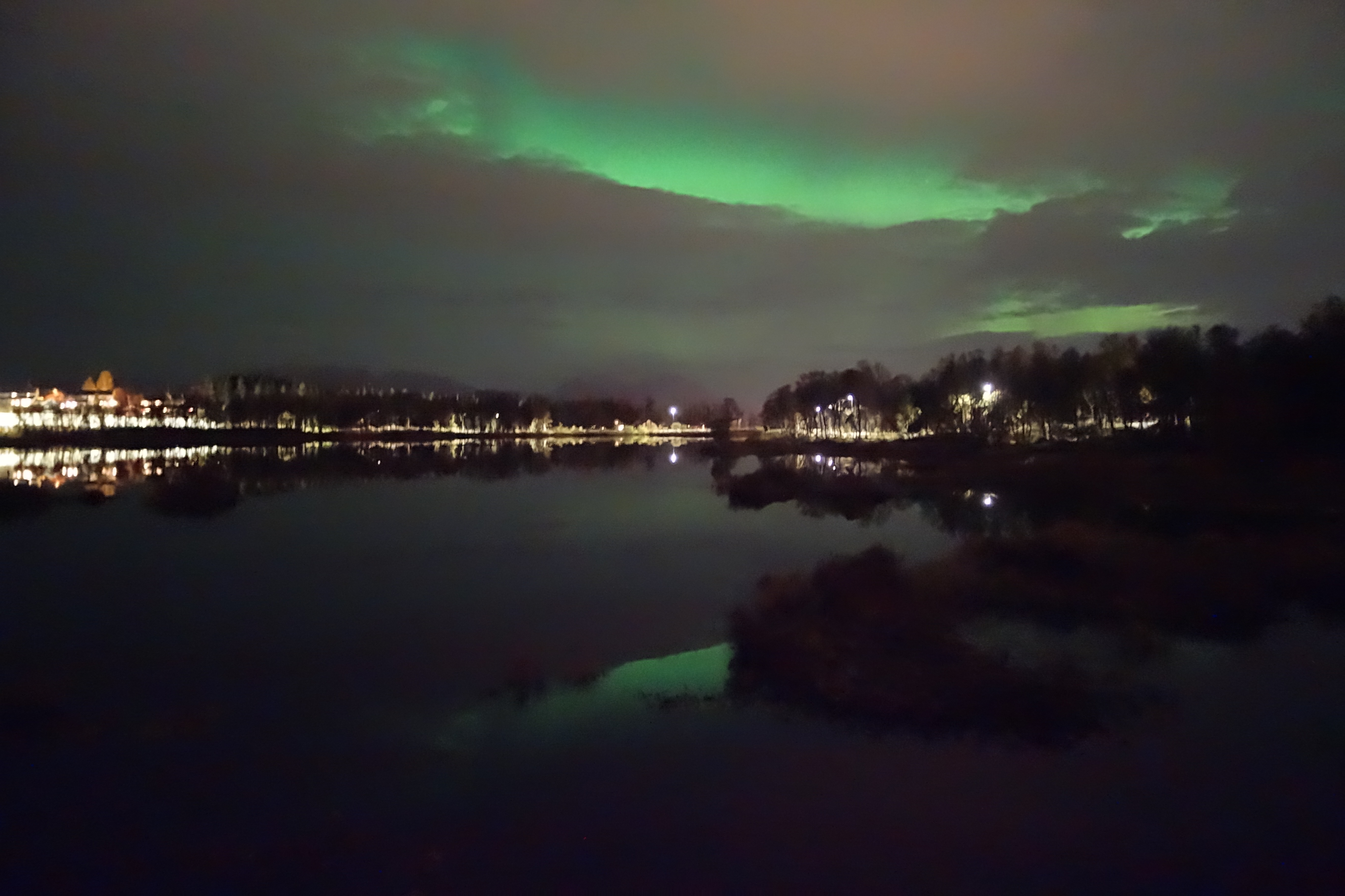 Das schwache grüne Nordlicht, das wir nach dem Warten in der Kälte über einem dunklen See bei Tromso gesehen haben.