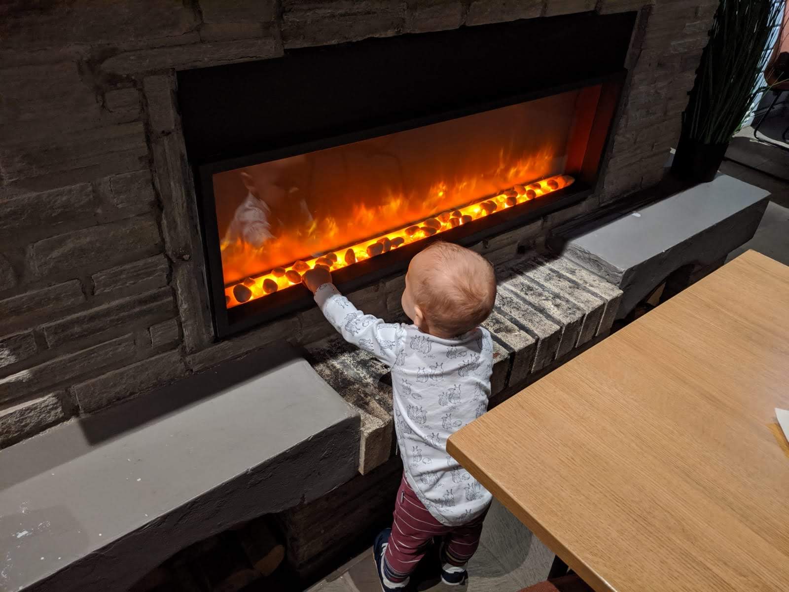 Mein Sohn wärmt sich am Kamin im Cafe auf dem Storsteinen, nachdem ihm am Aussichtspunkt kalt geworden war.