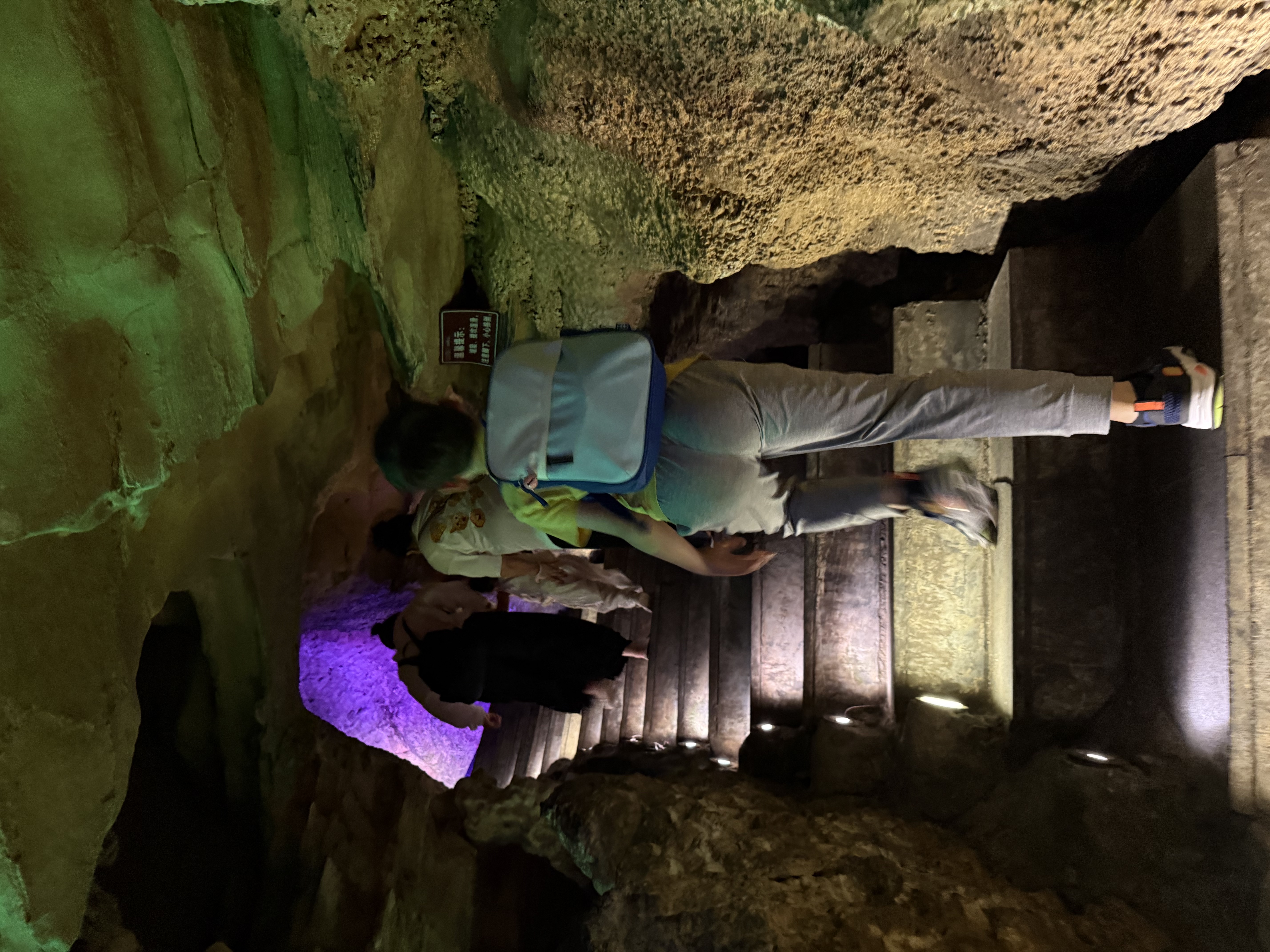 My son and other visitors climb a brightly lit staircase inside Tianhetan’s dry cave.
