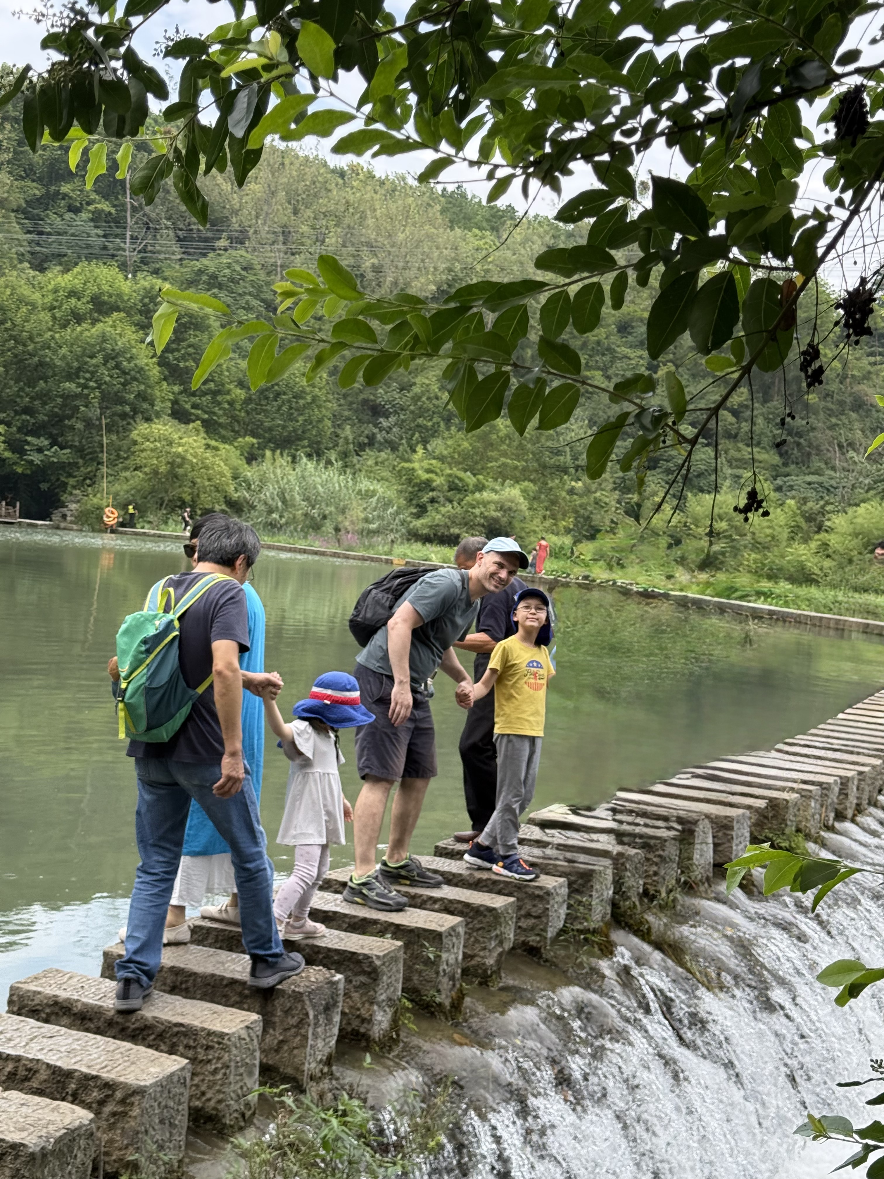 Our group crossing stepping stones beside the water at Tianhetan.