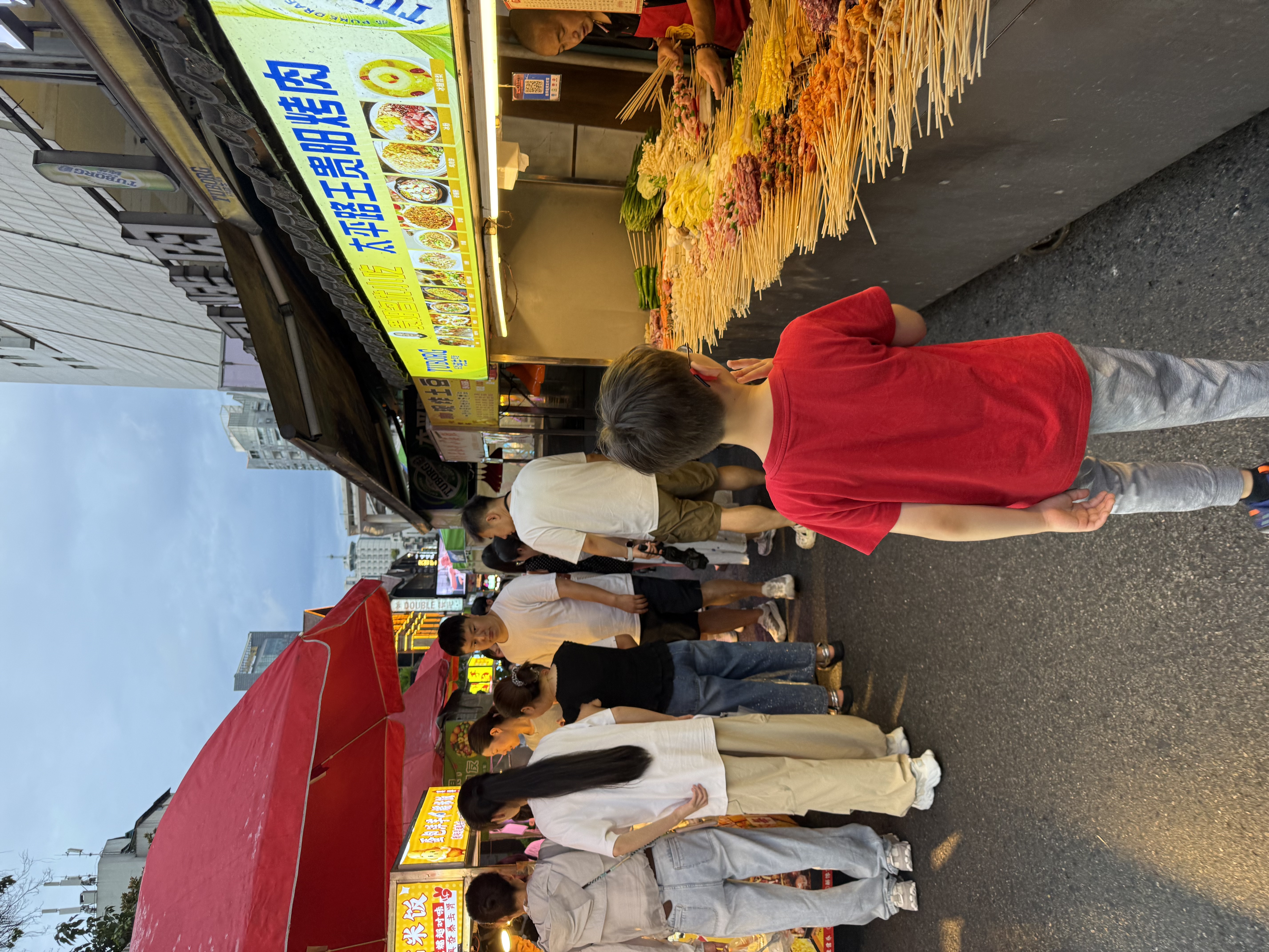 Notre fils passe devant les stands de nourriture du marché nocturne de Taiping Road.
